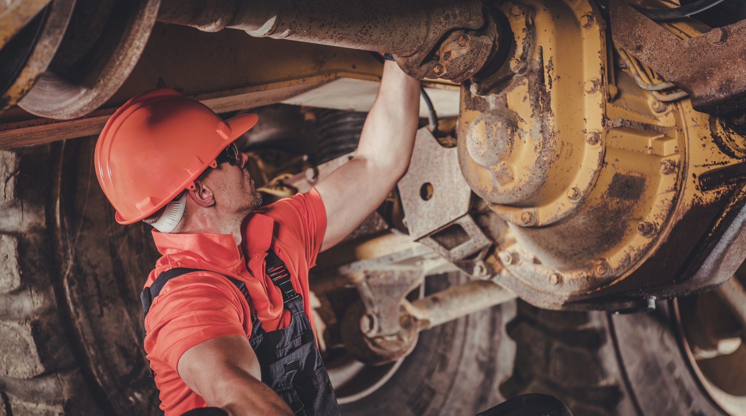 An image of a driver trying to bush fix a Heavy Duty Equipment Problem.